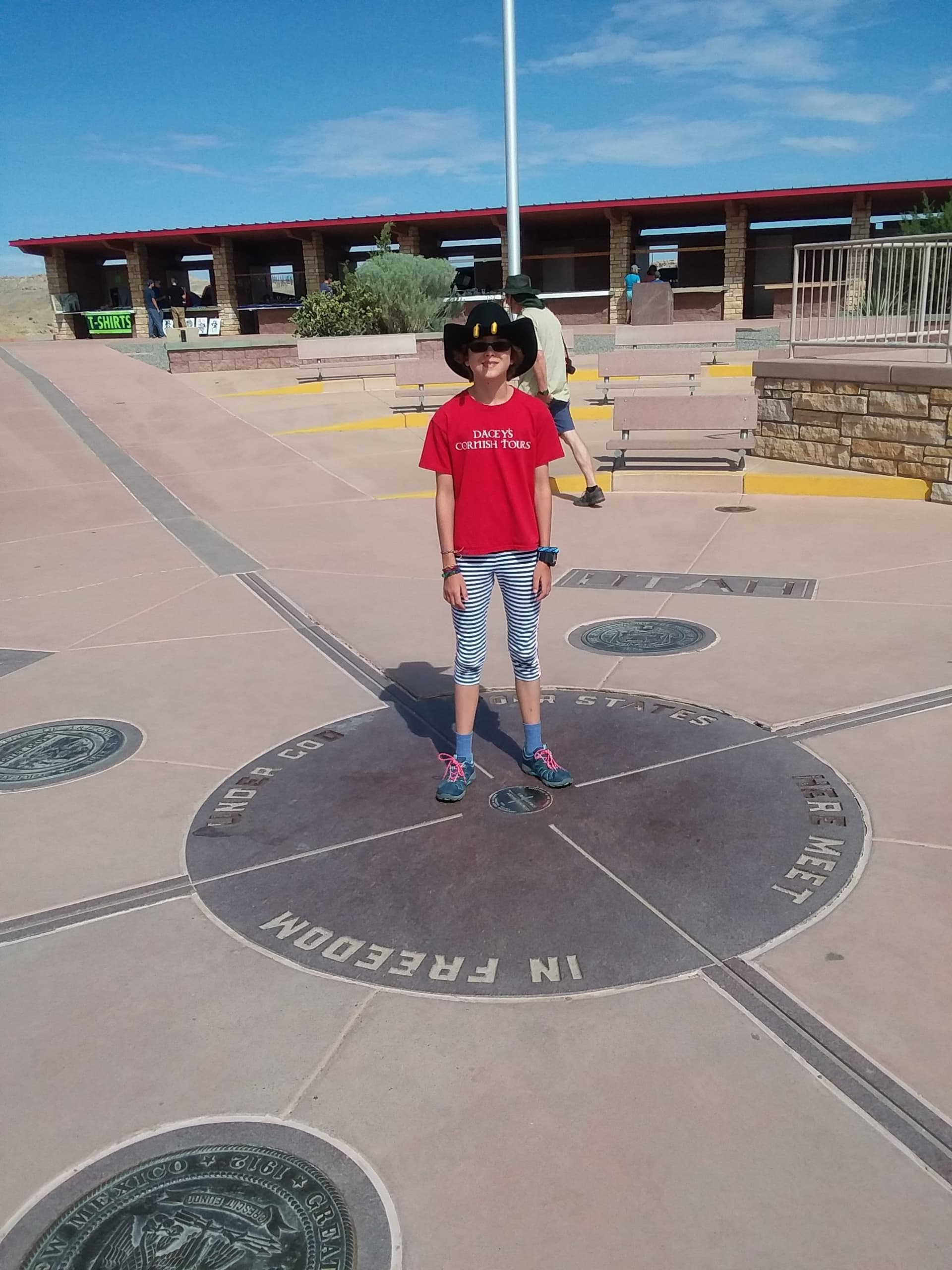 Sophie, standing at Four Corners Monument, USA